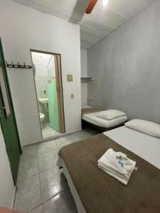 Habitación con 2 camas, espejo y baño. en Pousada Alto Mar Saquarema, en Saquarema
