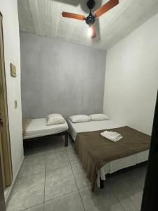 2 camas en una habitación con ventilador de techo en Pousada Alto Mar Saquarema, en Saquarema