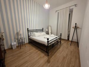a bedroom with a bed in a room with striped walls at MR House - by Be Your Home in Rome