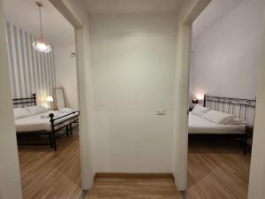 a hallway leading to two beds in a room with white walls at MR House - by Be Your Home in Rome
