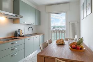 een keuken met een tafel met daarop een schaal fruit bij Casa Gabbiano by Ca-sa Check in Chioggia