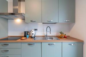 een keuken met witte kasten en een spoelbak bij Casa Gabbiano by Ca-sa Check in Chioggia