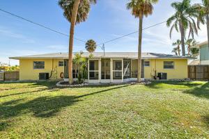 una casa gialla con palme di fronte di Sun Baker III East a Anna Maria Island