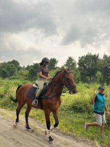 a woman is riding a horse on a road at Puunee Wild River Villa's Borobudur in Borobudur