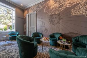 ラ・ロシェルにあるLe Champlainの緑の椅子と壁画のある壁のある部屋