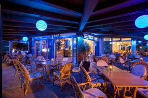 a restaurant with tables and chairs and lights at Hotel Playa e Mare Nostrum in Caorle