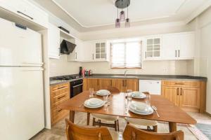 una cucina con un tavolo di legno e alcune sedie di Villa Serafina a Mergenli