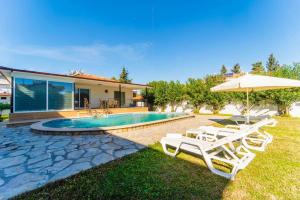 dom z basenem z krzesłami i parasolem w obiekcie Villa Sena w mieście Dalyan