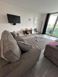 #310 Sunny Isles Ocean Reserve Parking include في صني آيلز بيتش: غرفة معيشة مع أريكة وتلفزيون بشاشة مسطحة