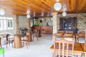 a restaurant with wooden ceilings and tables and chairs at Hotel Sonnet by Estância Santa Cruz in Curitiba