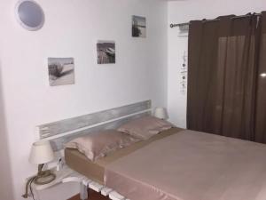 Un dormitorio con una cama y una mesa con una lámpara. en Bungalow confortable avec piscine à Le Lamentin, en La Belème 16 fotos más
