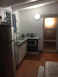cocina con nevera de acero inoxidable y puerta abierta en Bungalow confortable avec piscine à Le Lamentin, en La Belème