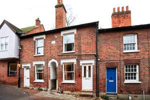 een oud bakstenen huis met een blauwe deur bij Cottage in the centre in Colchester