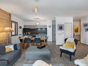 a living room with a couch and a table at L'O Rouge - Apt A02 - BO Immobilier- remises sur les forfaits de skis Châtel ou Portes du soleil in Châtel +9 photos