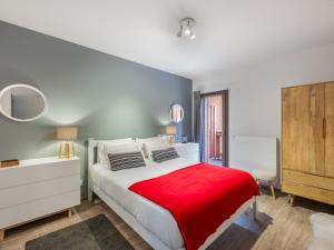 a bedroom with a white bed with a red blanket at L'O Rouge - Apt A02 - BO Immobilier- remises sur les forfaits de skis Châtel ou Portes du soleil in Châtel