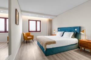a bedroom with a blue bed and a yellow chair at Casa da Praia - Matosinhos Mar in Matosinhos