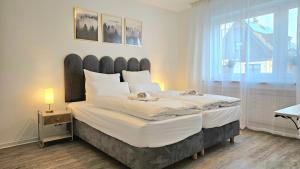 Una cama o camas en una habitación de 3 Zimmer I Küche I Balkon I WLAN I Parken I Seepark