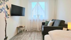 Una televisión o centro de entretenimiento en 3 Zimmer I Küche I Balkon I WLAN I Parken I Seepark