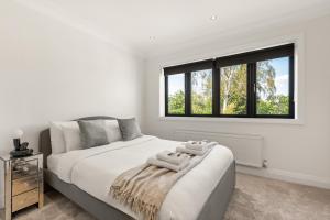 En eller flere senge i et værelse på New! Trendy 5BR with Garden and Parking near Wimbledon