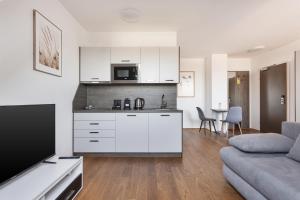 una cucina e un soggiorno con un divano e una TV di Hotel Triester a Vienna