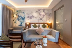 a hotel room with a couch and a bed at Wyndham Garden Jim Corbett Chhoi in Belparāo +48 photos