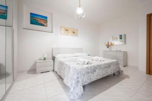 una camera da letto bianca con un letto e un tavolo di Casa di Titina a Otranto a Otranto