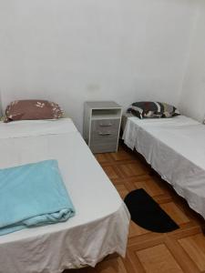 2 letti in una camera con pavimento in legno di LA MAXIMIANa a Libertador General San Martín