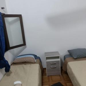 una camera da letto con due letti e uno specchio di LA MAXIMIANa a Libertador General San Martín