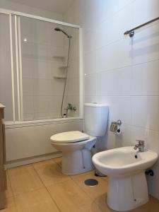 ein Badezimmer mit Toilette und Waschbecken in der Unterkunft 2-bedroom apartment with pool, 5-minute walk to the beach in São Martinho do Porto + 1 Foto