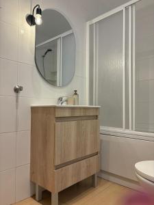 ein Badezimmer mit Waschbecken und Spiegel in der Unterkunft 2-bedroom apartment with pool, 5-minute walk to the beach in São Martinho do Porto