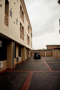 ラゴスにあるKaashmeen Hotel & Suiteの建物の隣の駐車場に駐車された車