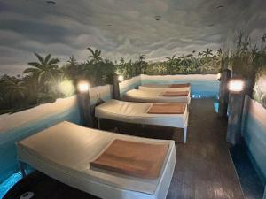 a room with four beds and a swimming pool at Hotel Phönix in Bad Füssing