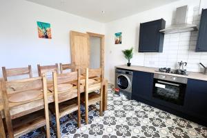 eine Küche mit einem Tisch, Stühlen und einem Geschirrspüler in der Unterkunft Nursery House Retreat in Heptonstall