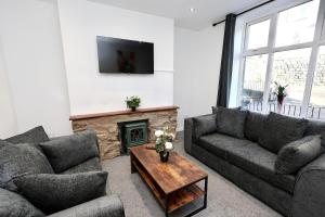 ein Wohnzimmer mit zwei Sofas und einem Kamin in der Unterkunft Nursery House Retreat in Heptonstall