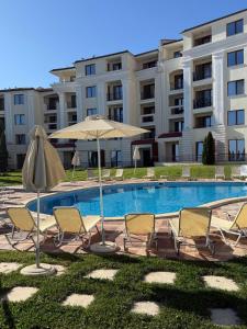una piscina con sedie e ombrelloni accanto a un edificio di Infinity Blue Apartment-Complex Carpe Diem - FREE PARKING a Balchik