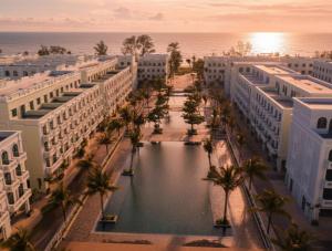 an aerial view of buildings with palm trees and the ocean at HADU Hotel & Café Phu Quoc in Phú Quốc