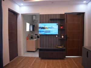 a living room with a television and a kitchen at HomeGround Sector 89 -1RK in Gurgaon