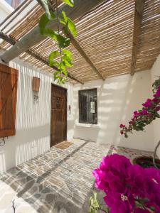 a room with a wooden door and purple flowers at Casapueblo Rent Cachagua CP 29 in Cachagua