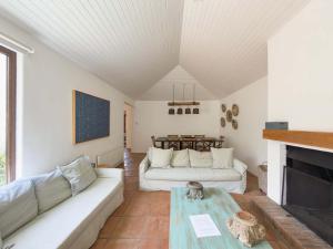 a living room with two white couches and a fireplace at Casapueblo Rent Cachagua CP 29 in Cachagua