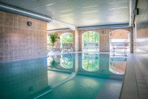 Una piscina con mesas y sillas en un edificio. en Ferienwohnung Freudensee im Bayerischen Wald - Pool, Sauna, en Hauzenberg