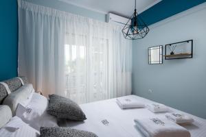 Sea and City Voula Suite by First Class Properties في أثينا: غرفة نوم بسرير أبيض ونافذة