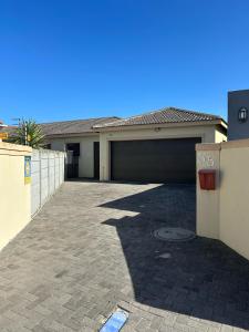 een huis met een garage en een oprit bij Holiday Home in Cape Town