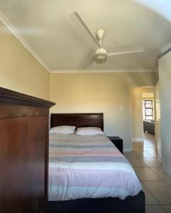 een slaapkamer met een bed met een plafondventilator bij Holiday Home in Cape Town