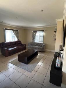 een woonkamer met een bank en een salontafel bij Holiday Home in Cape Town