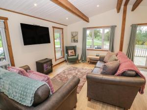 a living room with two couches and a flat screen tv at Oak Lodge in Rugeley