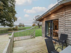 a wooden deck with two chairs and a table at Oak Lodge in Rugeley