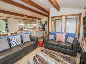 a living room with two couches and a kitchen at Willow Lodge in Rugeley
