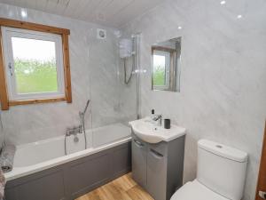 a bathroom with a sink and a tub and a toilet at Willow Lodge in Rugeley +20 photos