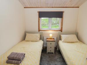 two twin beds in a small room with a window at Willow Lodge in Rugeley