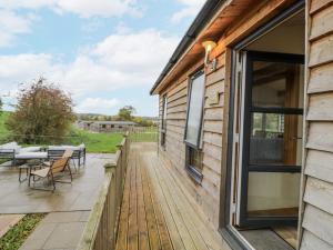a deck with a table and chairs on a house at Willow Lodge in Rugeley
